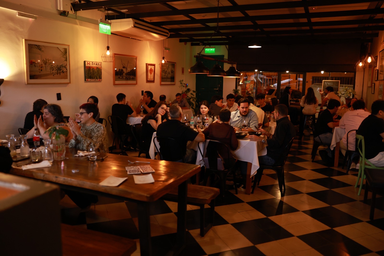 A stunning, atmospheric shot of a modern restaurant interior with minimalist decor, warm lighting, and lush green plants, creating an elegant and inviting ambiance. professional food photography